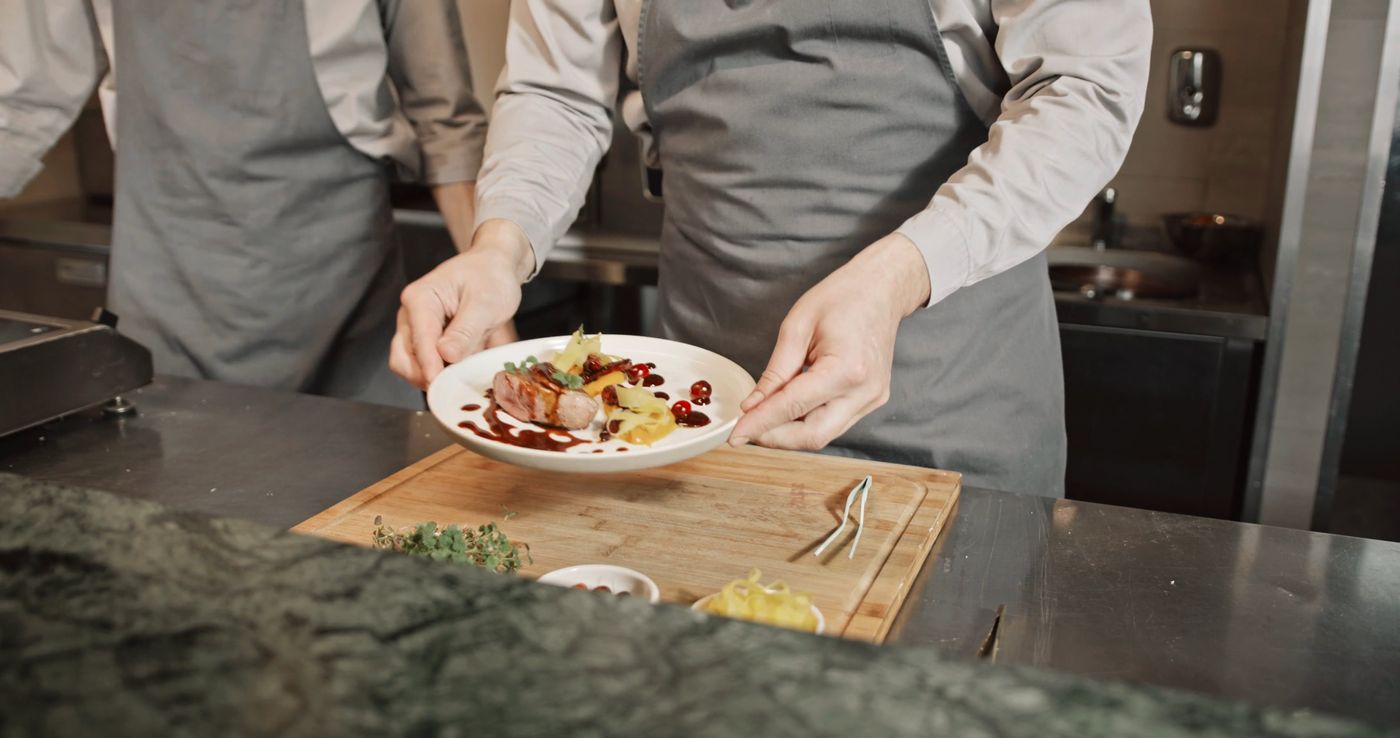 Chef emplatando cuidadosamente en una cocina profesional